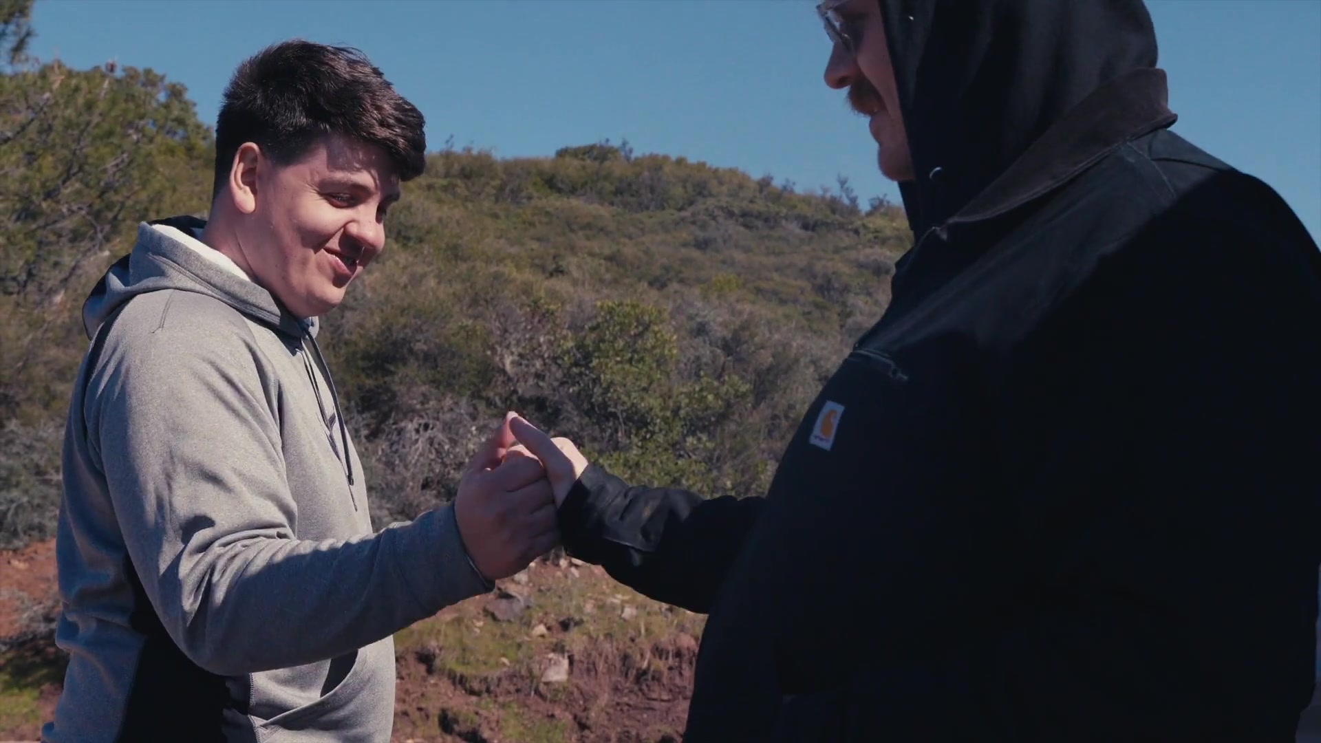 Two people greeting one another during daytime field work